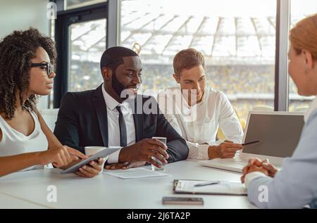Uomini d'affari multirazziali che lavorano insieme in ufficio Foto Stock