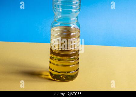Olio di girasole in lattina di plastica con fondo giallo e blu con la bandiera dell'ucraina Foto Stock