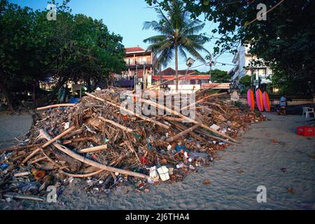 Enorme mucchio di rifiuti sulla spiaggia di Kuta a Bali al tramonto in attesa di essere portato via. Foto Stock