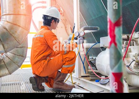 L'operatore elettricista ispeziona e controlla il riscaldamento, il condizionamento dell'aria (HVAC) e il servizio di condizionamento dell'aria nella piattaforma offshore del carro di perforazione dell'olio Foto Stock