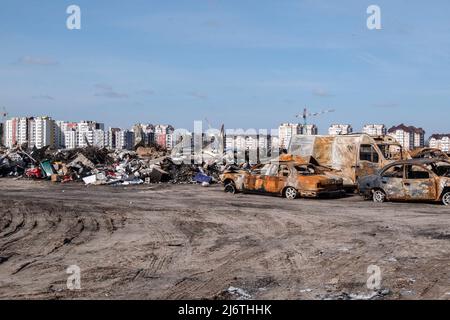 Parcheggio di auto danneggiate dopo l'occupazione russa. Buca, una città alla periferia della capitale Ucraina Kiev, è stata controllata dai soldati russi per circa un mese. La sua liberazione il 31 marzo ha rivelato alcune delle atrocità più crudeli commesse dai soldati russi durante l'occupazione. Gli edifici furono distrutti e le case saccheggiate. Corpi morti sono stati trovati in strade Bucha, edifici e tombe di massa. Foto Stock