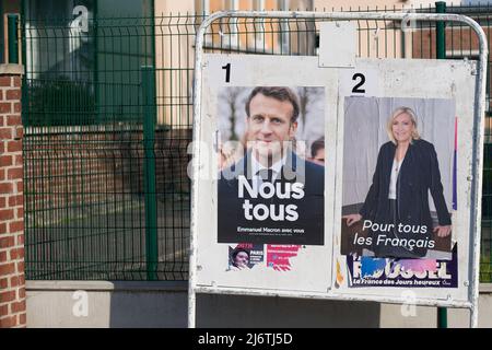 AMIENS, FRANCIA - 28 APRILE 2022 : Poster di campagna per il secondo turno delle elezioni presidenziali francesi, di fronte a un seggio elettorale. Foto Stock