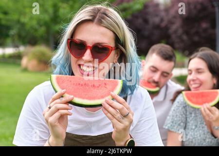Felice giovane donna sorridente tenendo un pezzo di cocomero. Foto Stock