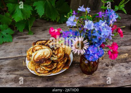 Cottura e bacche su sfondo di legno con fiori Foto Stock
