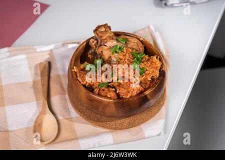 Gustoso riso nigeriano Jollof servito e decorato con spezie verdi e pollo Foto Stock