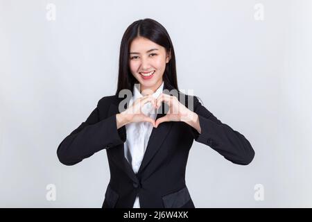 bella donna attraente mani emotive mostrando la forma del cuore sulla sua mano, donna d'affari ritratto positivo indossando abbigliamento da ufficio riuscito. Foto Stock
