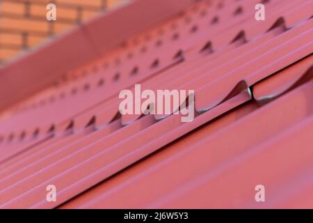 Costruzione del tetto la casa. Piastrelle rosse di metallo Foto Stock