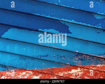 Immagine astratta dello scafo di una nave di colore rosso e blu con vernice da peeling Foto Stock