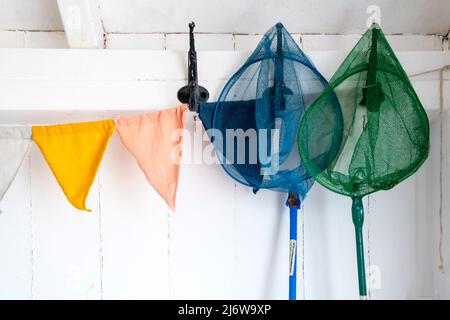 Colorate reti da gamberetto per bambini appese in una capanna sulla spiaggia a Wells-next-the-Sea sulla costa nord del Norfolk. Foto Stock
