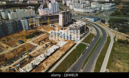 Grande cantiere. Costruzione di moderni edifici residenziali a più piani. Costruzione di edifici in cemento e vetro. AERIA Foto Stock