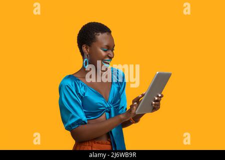 Felice afroamericana signora utilizzando moderno tablet digitale Foto Stock