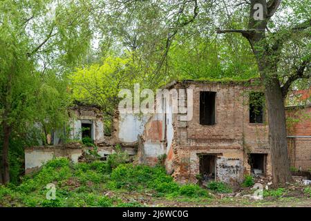 Vecchia casa in mattoni rossi dilapidati senza finestre e tetto Foto Stock