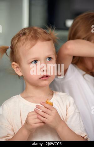 Ragazza sorridente carina con sushi su sfondo bianco. Bambina che mangia sushi e panini - concetto commerciale. Foto Stock