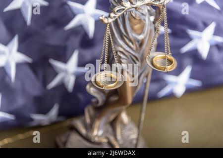 La statua di giustizia Themis o Iustitia, la dea della giustizia bendata contro una bandiera degli Stati Uniti d'America, come un concetto legale. Foto Stock