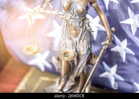 La statua di giustizia Themis o Iustitia, la dea della giustizia bendata contro una bandiera degli Stati Uniti d'America, come un concetto legale. Foto Stock