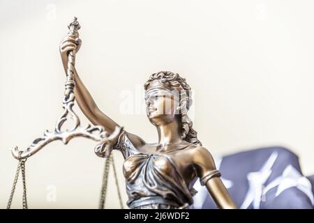 La statua di giustizia Themis o Iustitia, la dea della giustizia bendata contro una bandiera degli Stati Uniti d'America, come un concetto legale. Foto Stock