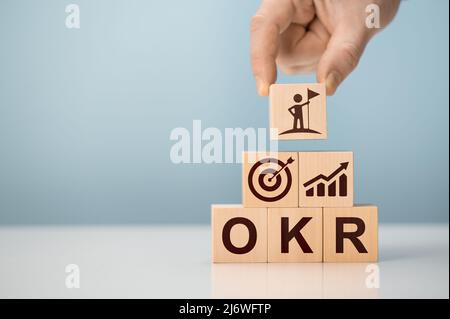 OKR obiettivi, chiave e risultati blocchi di cubo di legno su sfondo blu. Obiettivo aziendale e promuovere il business e le prestazioni. Business e OKR - obiettivi Foto Stock