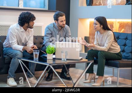 Elegante direttore aziendale che parla con i suoi colleghi Foto Stock