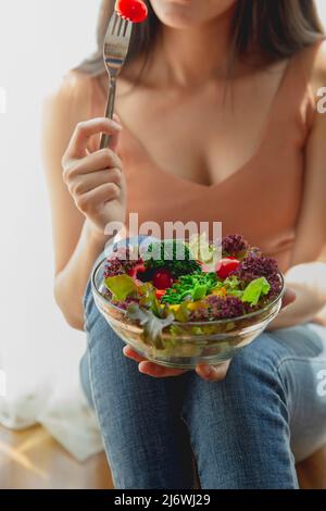 donna asiatica con cibo sano, bella ragazza che mangia un'insalata in casa, assistenza sanitaria mangiare verdure e alimenti utili stili di vita concetto. Foto Stock