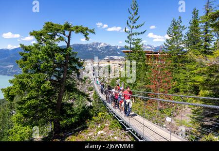 I turisti camminano sullo Sky Pilot Suspension Bridge Squamish B.C. un'attrazione sul mare a Sky Gondola giro alla cima Foto Stock