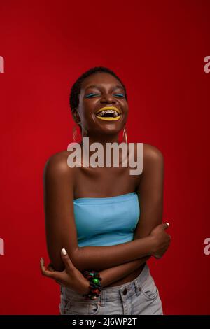 Primo piano ritratto di ridere elegante donna nera, verticale scatto Foto Stock