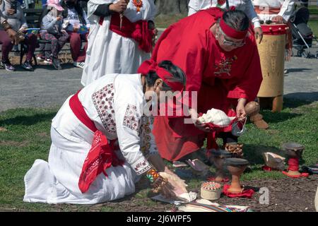 I membri del gruppo di danza messicana calpulli esprimono gratitudine alla Terra che esegue un antico rituale azteco. A Queens, New York. Foto Stock