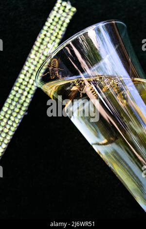 Pericolo di deglutire vespe in estate. Bere con la vespa in un bicchiere Foto Stock