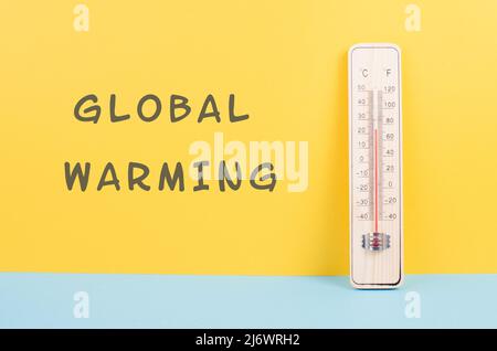 Termometro su sfondo giallo e blu, misura la temperatura, le previsioni del tempo, il riscaldamento globale e la discussione ambientale, i mari estivi Foto Stock