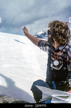 Una guida alpina nelle Alpi svizzere la Svizzera indica la strada navigando per mappa e bussola Foto Stock