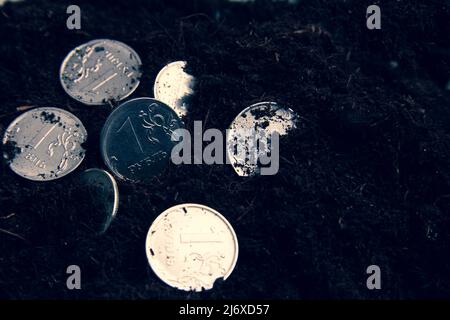 Moneta nel terreno. Soldi sparsi a terra. Il deprezzamento del rublo. La caduta della valuta. Variazione del tasso di cambio. Foto Stock