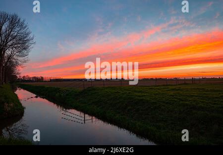 Tramonto rosso sul paesaggio olandese causato dalla sabbia del sahara nell'atmosfera Foto Stock