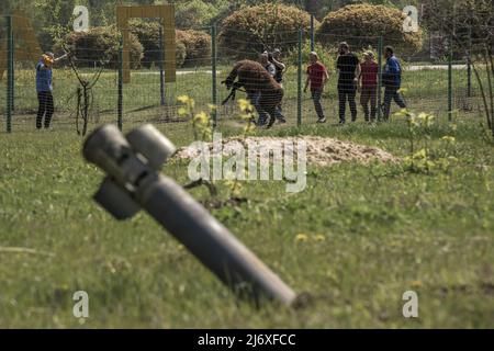 Un ordigno inesploso si stacca dal suolo mentre i dipendenti di Eco-Park inseguono un lama per essere salvati e portati nella città di Poltava per la sicurezza dopo che i russi hanno abbattuto la zona, uccidendo decine di animali al di fuori di Kharkiv, Ucraina lunedì 2 maggio 2022. Mercoledì la Russia ha sparato razzi incendiari nella seconda città più grande dell'Ucraina -- che ha acceso un grande incendio in un quartiere civile di Kharkiv -- dopo aver intensificato gli attacchi missilistici attraverso il paese segnato da battaglia. Foto di Ken Cedeno/UPI Foto Stock