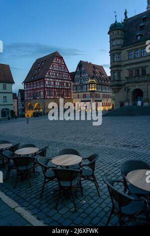 Bella architettura del romantico Rothenburg ob der Tauber con case in legno Fachwerkhaus syle in Baviera Germania al nicht con tavolo sul principale Foto Stock