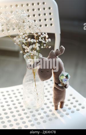 primo piano in alce giocattolo. elce giocattolo fatta a mano con fiori. arredamento Foto Stock