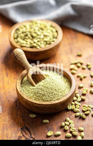 Caffè verde macinato e chicchi di caffè non tostati in un recipiente. Foto Stock