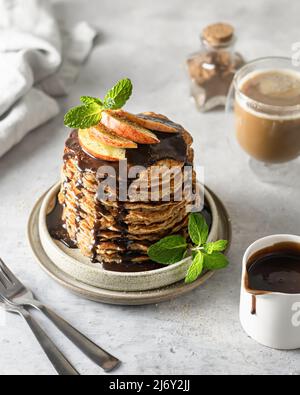 Stack di frittelle vegetariane di farinata d'avena per colazione decorate con frutta e menta Foto Stock