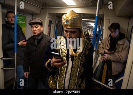 Mosca, Russia. 7th maggio 2022. Un uomo in un festoso costume nazionale dell'Asia centrale corre la metropolitana a Mosca, Russia Foto Stock