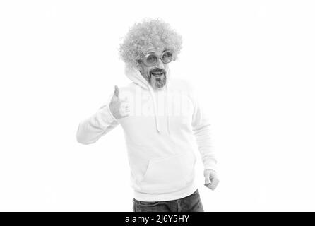 L'uomo divertente indossa funky parrucca capelli con gli occhiali da sole della festa mostrando pollici su gesto della mano, approvazione Foto Stock