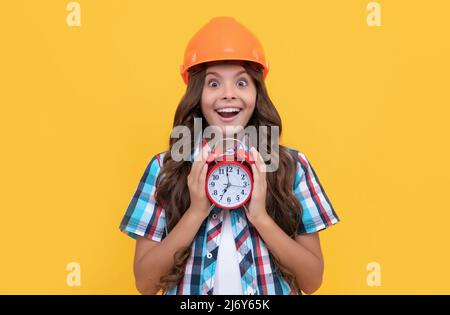 stupito bambino con capelli ricci in costruzione casco tenere sveglia, scadenza Foto Stock