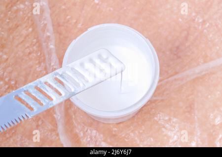 Un uomo imita vernice acrilica bianca con uno speciale agitatore in plastica. Verniciatura della porta. Foto Stock