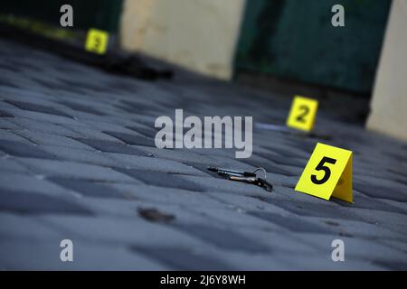 Prova con indicatore CSI giallo per la numerazione delle prove sul cortile interno in serata. Concetto del processo di indagine sulla scena del crimine Foto Stock