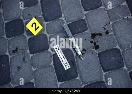 Prova con indicatore CSI giallo per la numerazione delle prove sul cortile interno in serata. Concetto del processo di indagine sulla scena del crimine Foto Stock