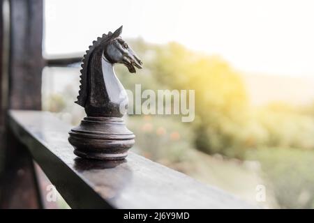 Pezzo di scacchi gigante cavallo sul balcone di legno di una casa di campagna o fattoria in una zona rurale Foto Stock