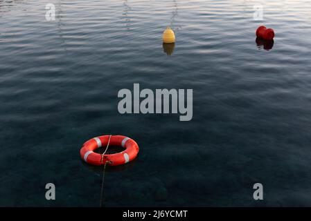 Lifebuoy e marcatrice galleggianti sul mare Foto Stock