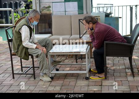 Uomini di Hong Kong che giocano a Xiangqi a Peng Chau, Hong Kong. Foto Stock