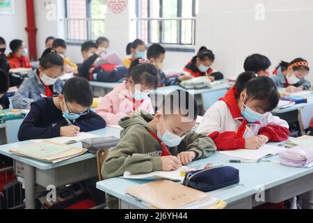 NANTONG, CINA - 5 MAGGIO 2022 - gli studenti della scuola primaria e media di Nantong City frequentano una classe nella città di Nantong, nella provincia di Jiangsu della Cina orientale, maggio Foto Stock