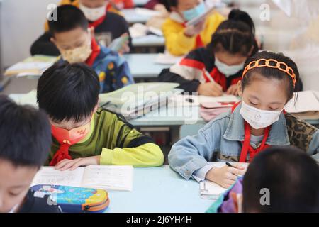 NANTONG, CINA - 5 MAGGIO 2022 - gli studenti della scuola primaria e media di Nantong City frequentano una classe nella città di Nantong, nella provincia di Jiangsu della Cina orientale, maggio Foto Stock