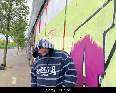 04 maggio 2022, Gran Bretagna, Belfast: Connor, 35, artista graffiti di Belfast si trova di fronte ad un muro dipinto. La Gran Bretagna elegge nuovi consigli locali e distrettuali. Per i Tories, scandalosi, del primo ministro Boris Johnson, ciò potrebbe essere spiacevole. (A dpa 'portent per Johnson? Elezioni regionali e locali in Gran Bretagna') Foto: Christoph Meyer/dpa Foto Stock