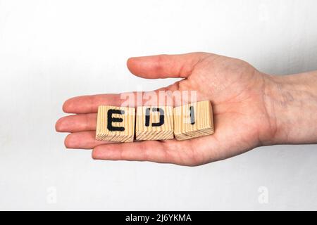 Scambio elettronico di dati EDI. Blocchi di legno alfabetici in una mano della donna. Foto Stock