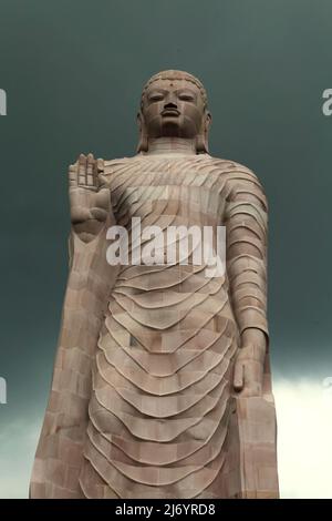 Una statua in pietra arenaria alta 80 piedi del Buddha in piedi a Sarnath alla periferia di Varanasi, Uttar Pradesh, India. Costruita dal 1997 al 2011, la statua fu il risultato di uno sforzo congiunto tra Thailandia e India. Foto Stock